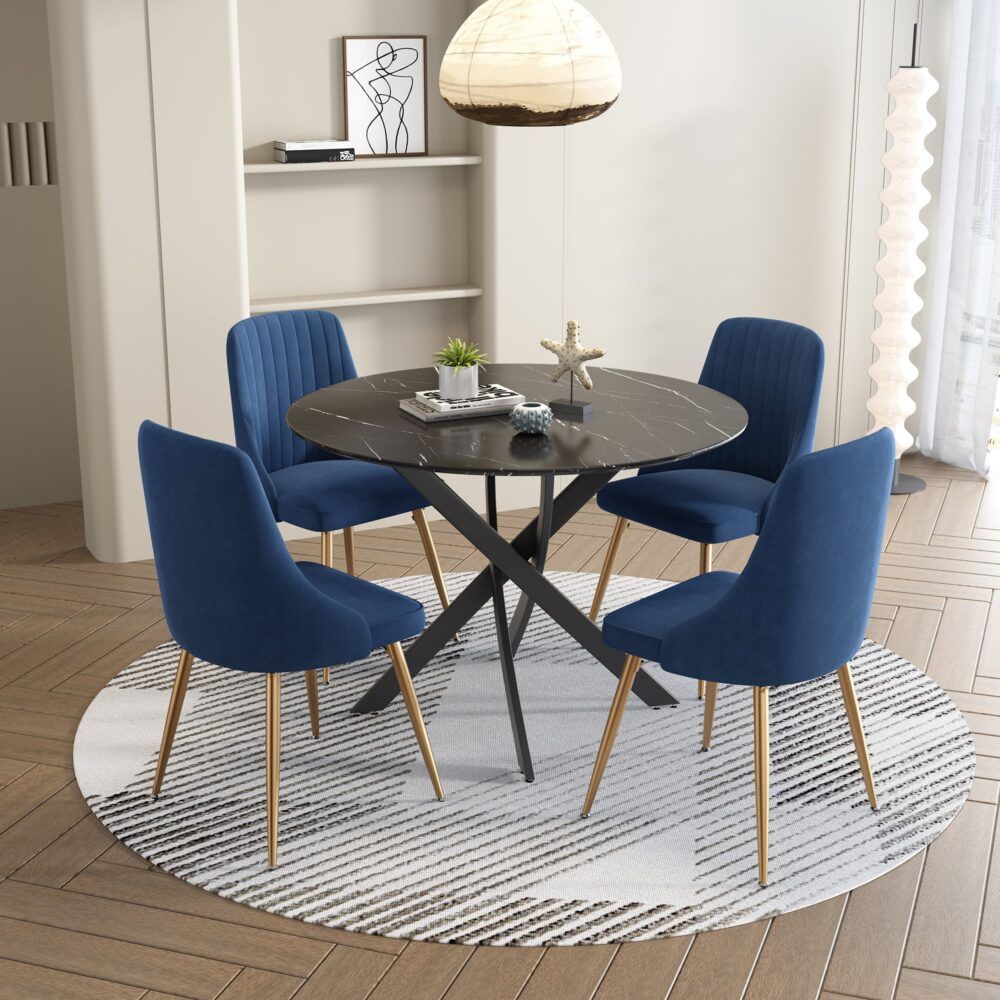 Round glass dining table with black X base and four blue velvet chairs