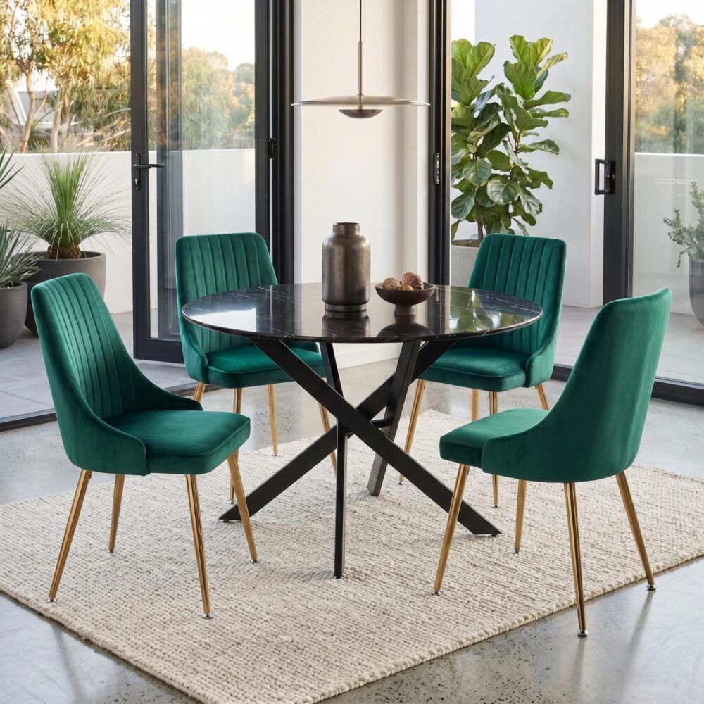 Round marble-look table with X-frame base and four teal velvet dining chairs