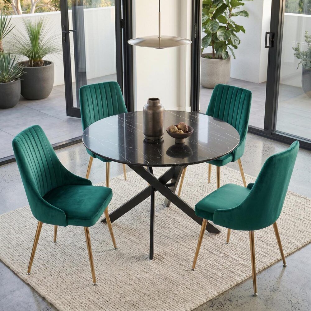 Dining table set with round marble-look top, black X legs, and four teal velvet chairs