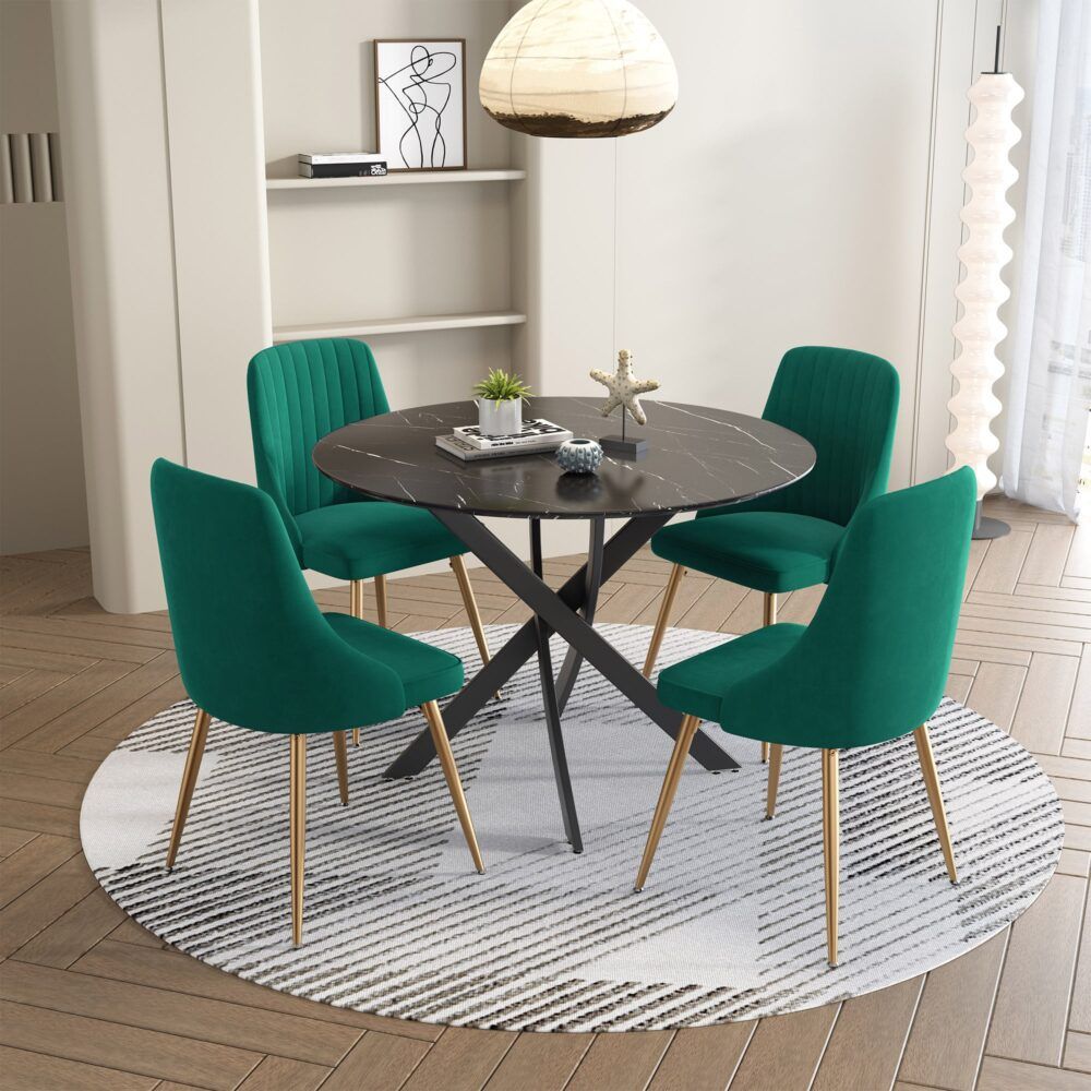 Round marble-look dining table with black X base and four teal velvet chairs
