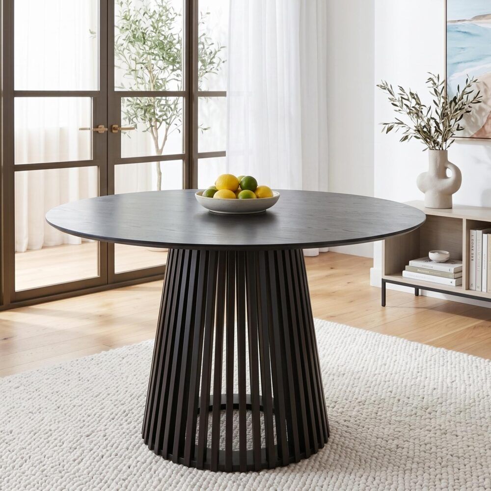 Round dining table with dark gray tabletop and ribbed black pedestal base