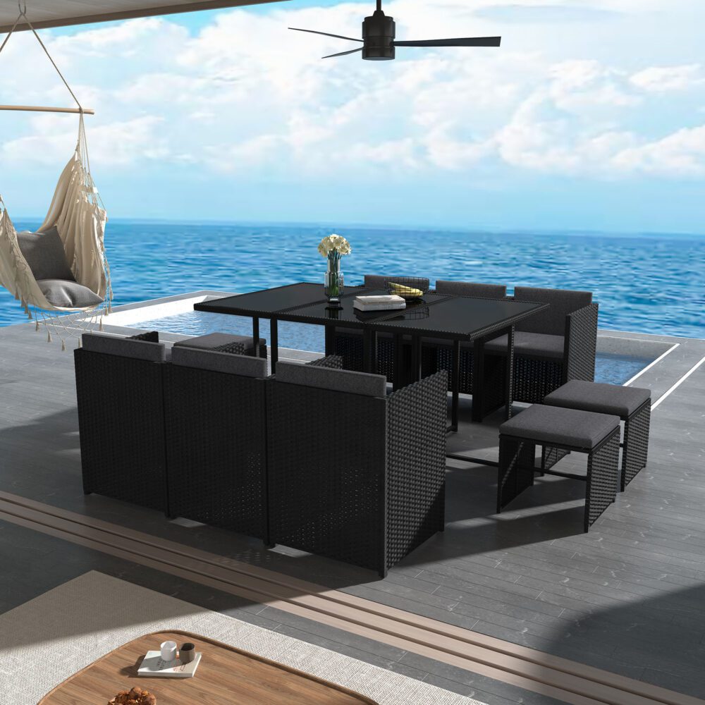 Black outdoor dining set on patio: square glass-top table with matching woven seating and cushions
