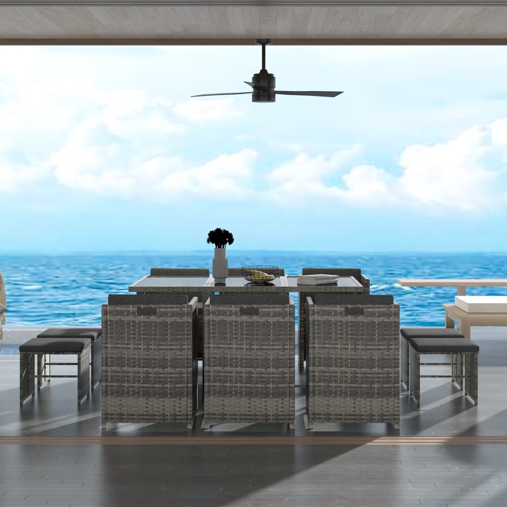 Grey outdoor dining set with glass-top table and woven chairs around center post