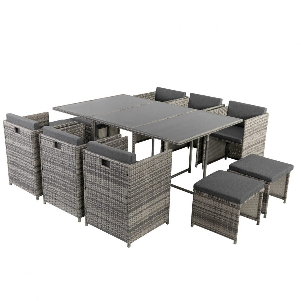 Grey outdoor dining set with glass-top table, woven chairs, and padded ottomans