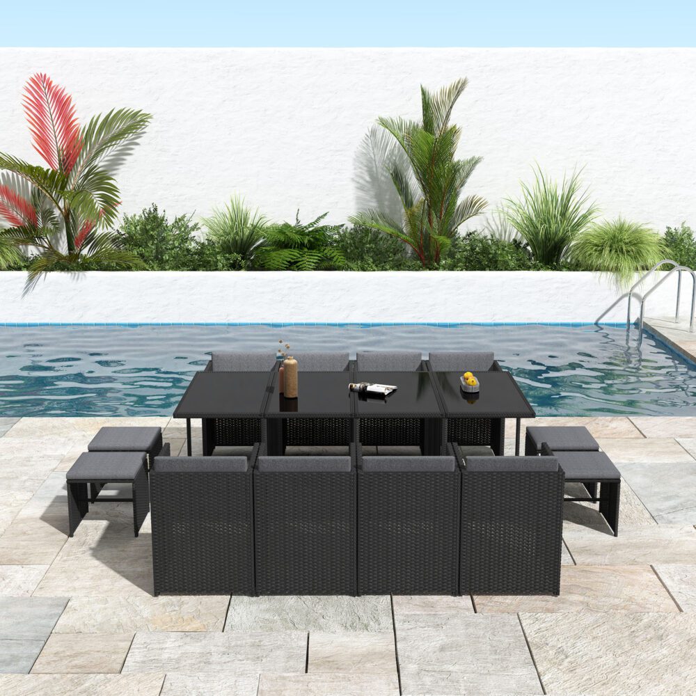 Black outdoor dining set with rectangular glass table and matching woven lounge seating