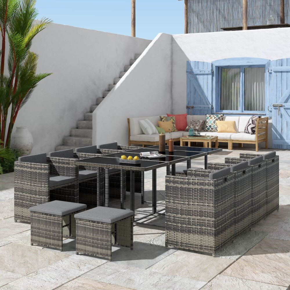 Grey outdoor dining furniture set with rectangular table, ottomans, and woven seating