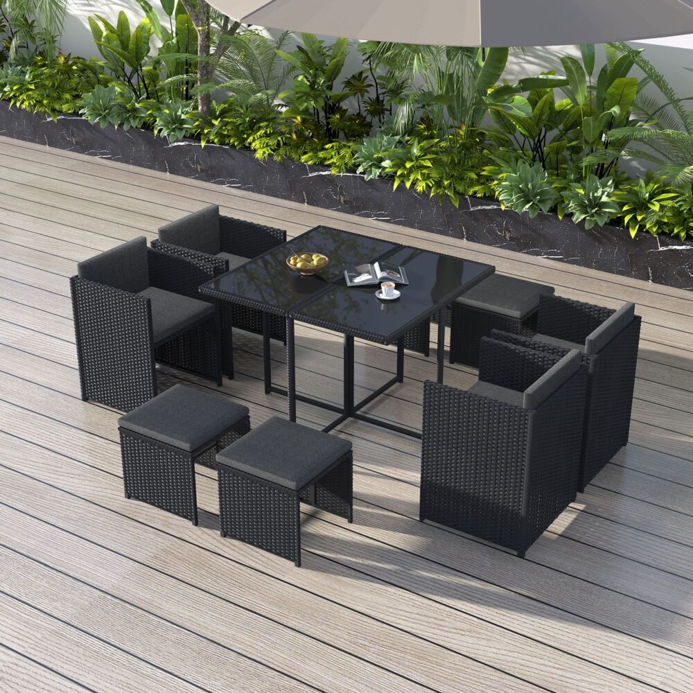 Black rattan outdoor dining set with rectangular table and cushioned ottomans