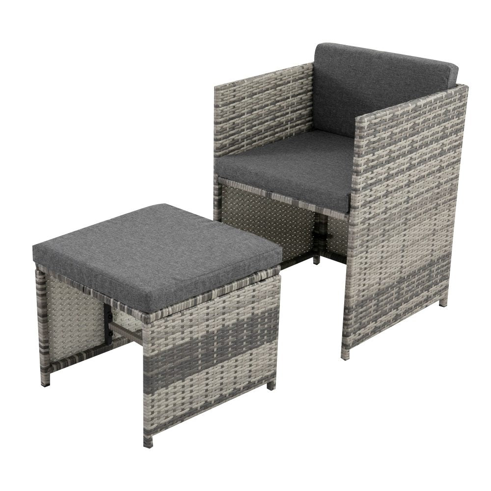Grey woven rattan outdoor armchair with dark grey seat cushion and matching ottoman