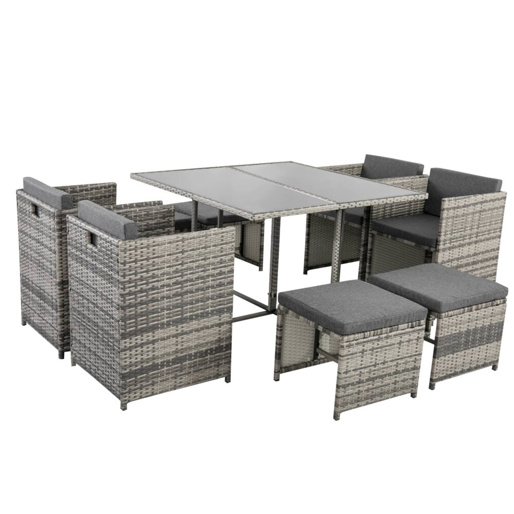 Outdoor dining set with grey woven rattan chairs, ottoman seats, and rectangular glass table