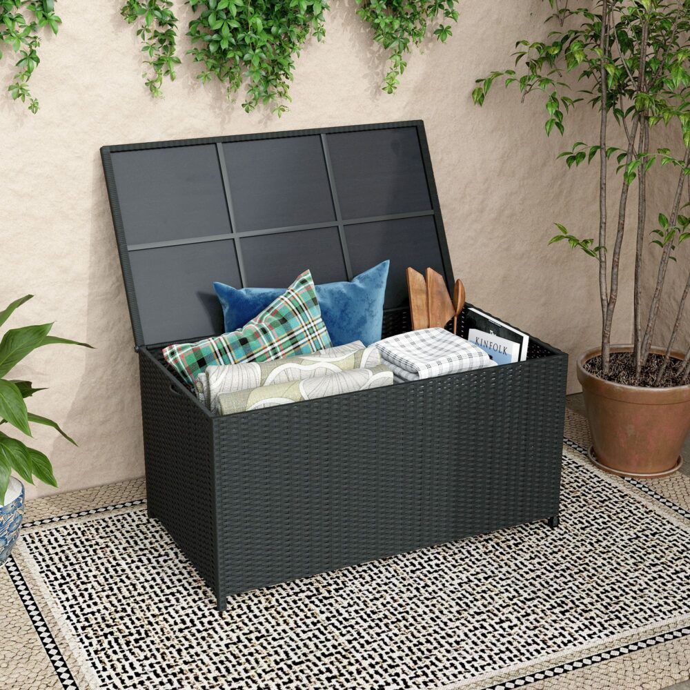 Outdoor storage box with hinged lid open, dark panel inserts, holding cushions.