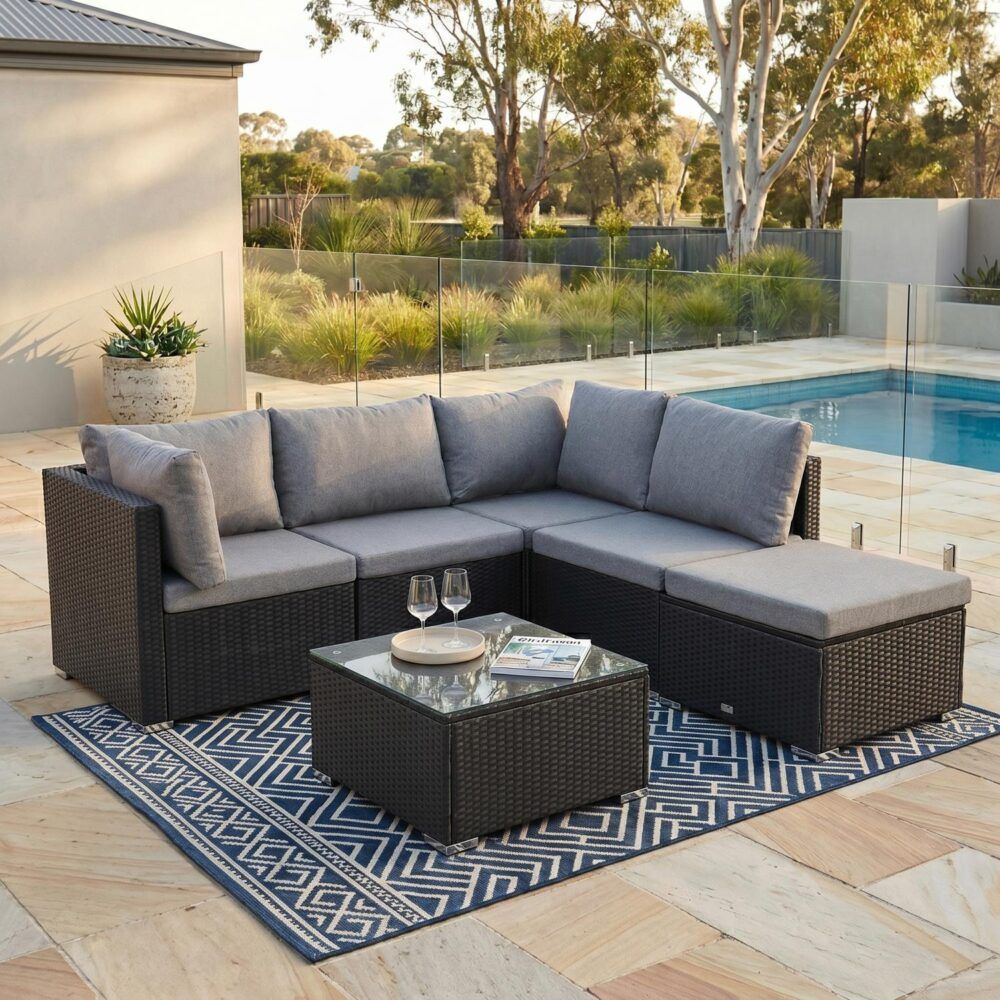 Black outdoor lounge sectional with gray cushions and corner ottoman coffee table