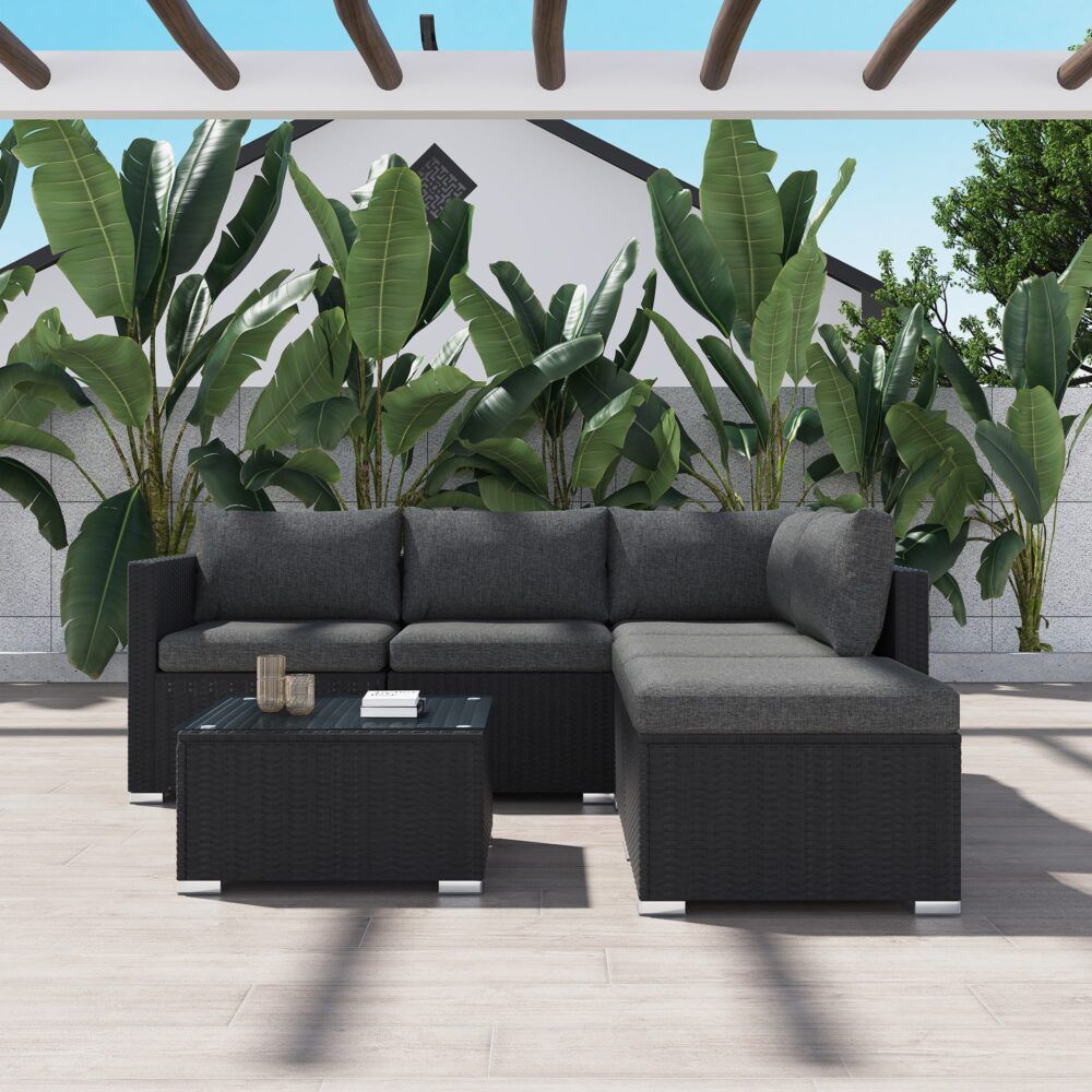 Black corner outdoor lounge sectional with gray cushions and glass-top ottoman table