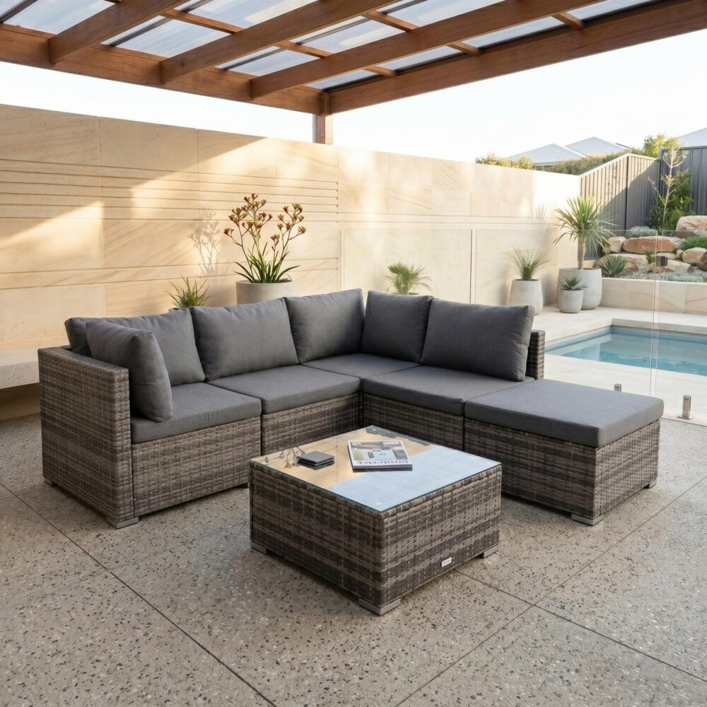 Outdoor ottoman-style sectional lounge set with grey back cushions and woven ottoman coffee table