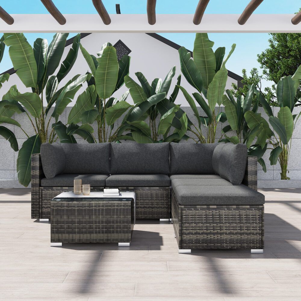 Outdoor ottoman-style sectional with grey seat cushions and woven ottoman coffee table