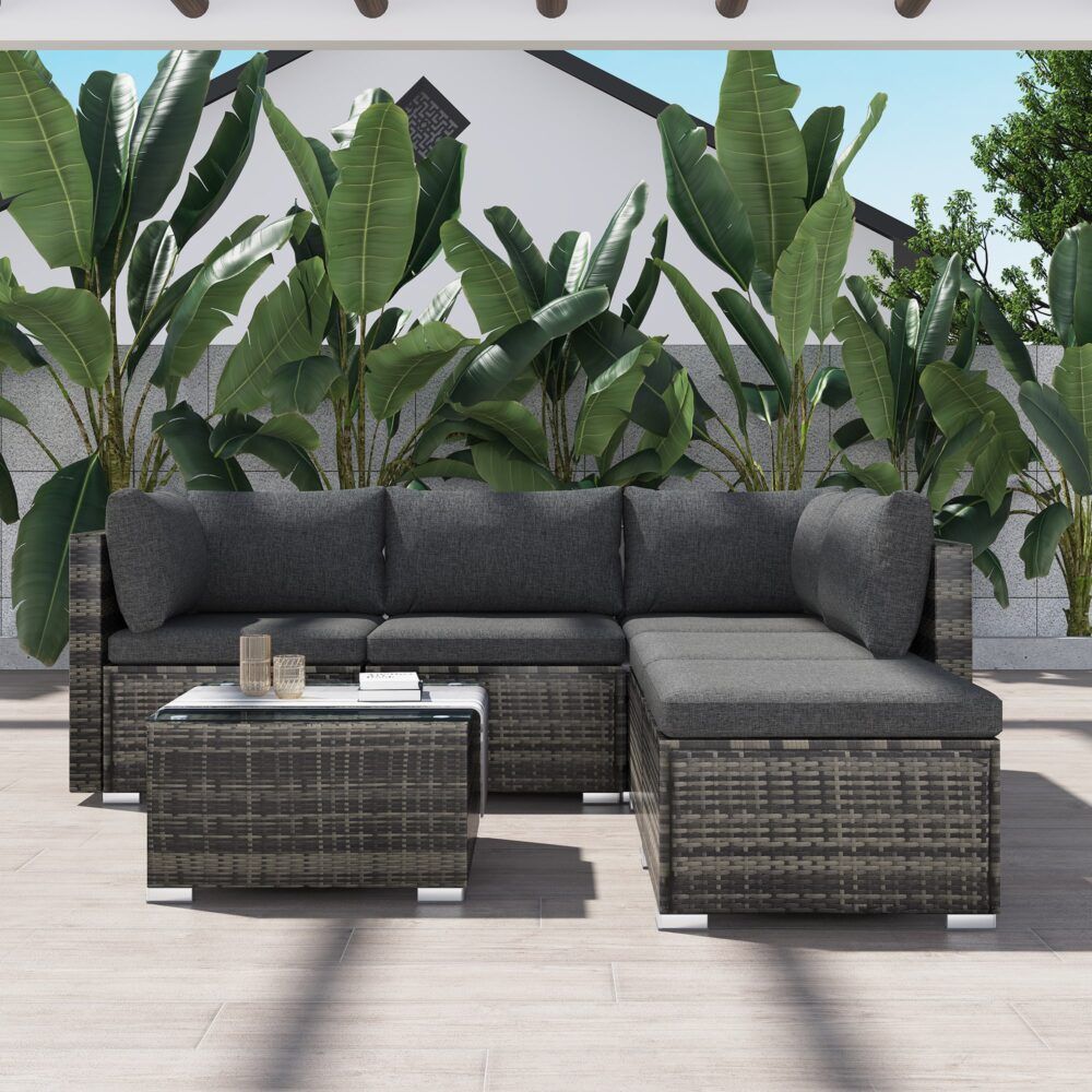 Outdoor ottoman-style sectional with grey back pillows and woven ottoman coffee table