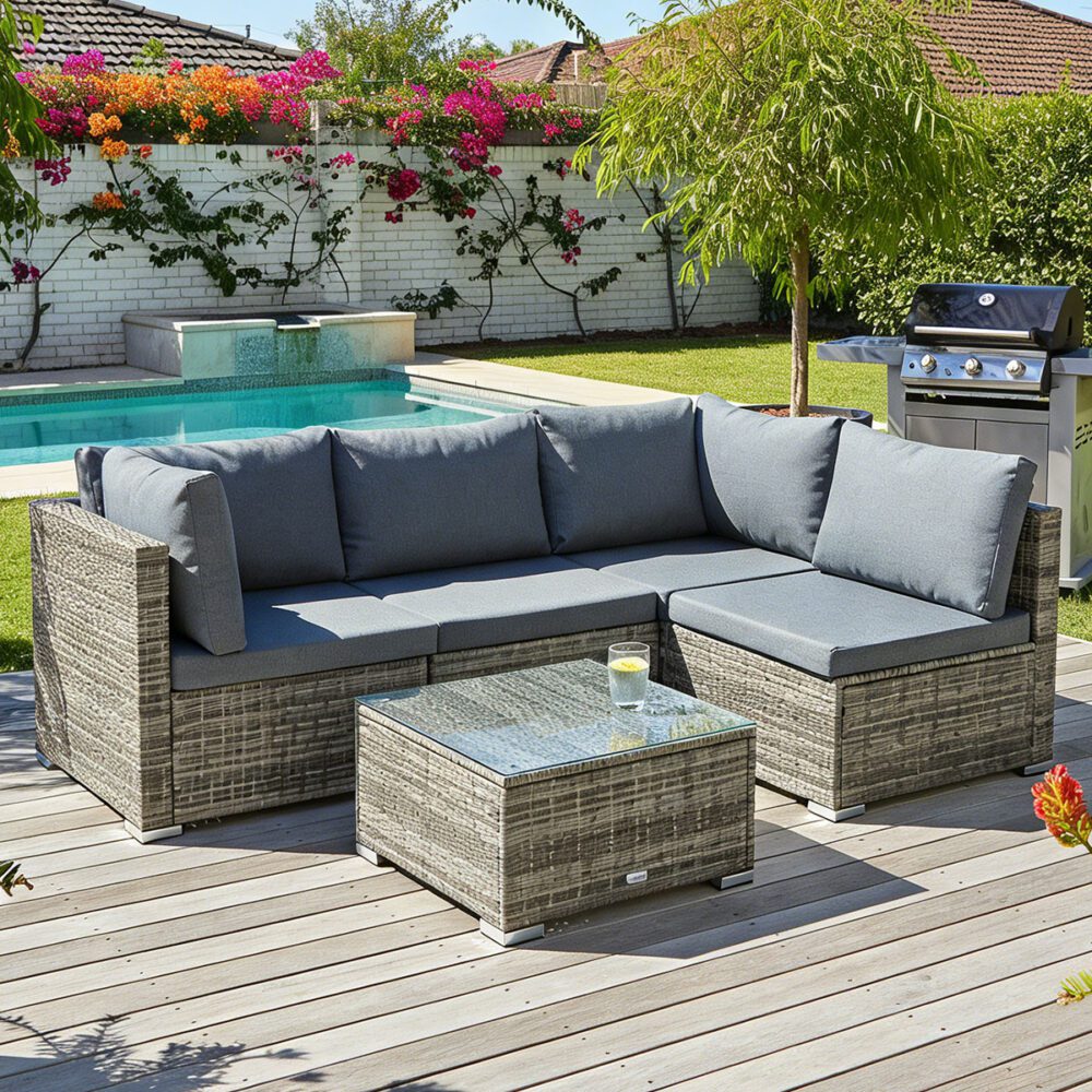 Outdoor modular lounge sofa set with dark gray cushions, woven frame, and glass-topped coffee table.
