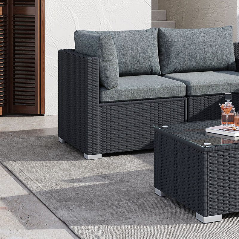 Outdoor modular lounge sofa chair section with dark woven frame and gray upholstered cushions