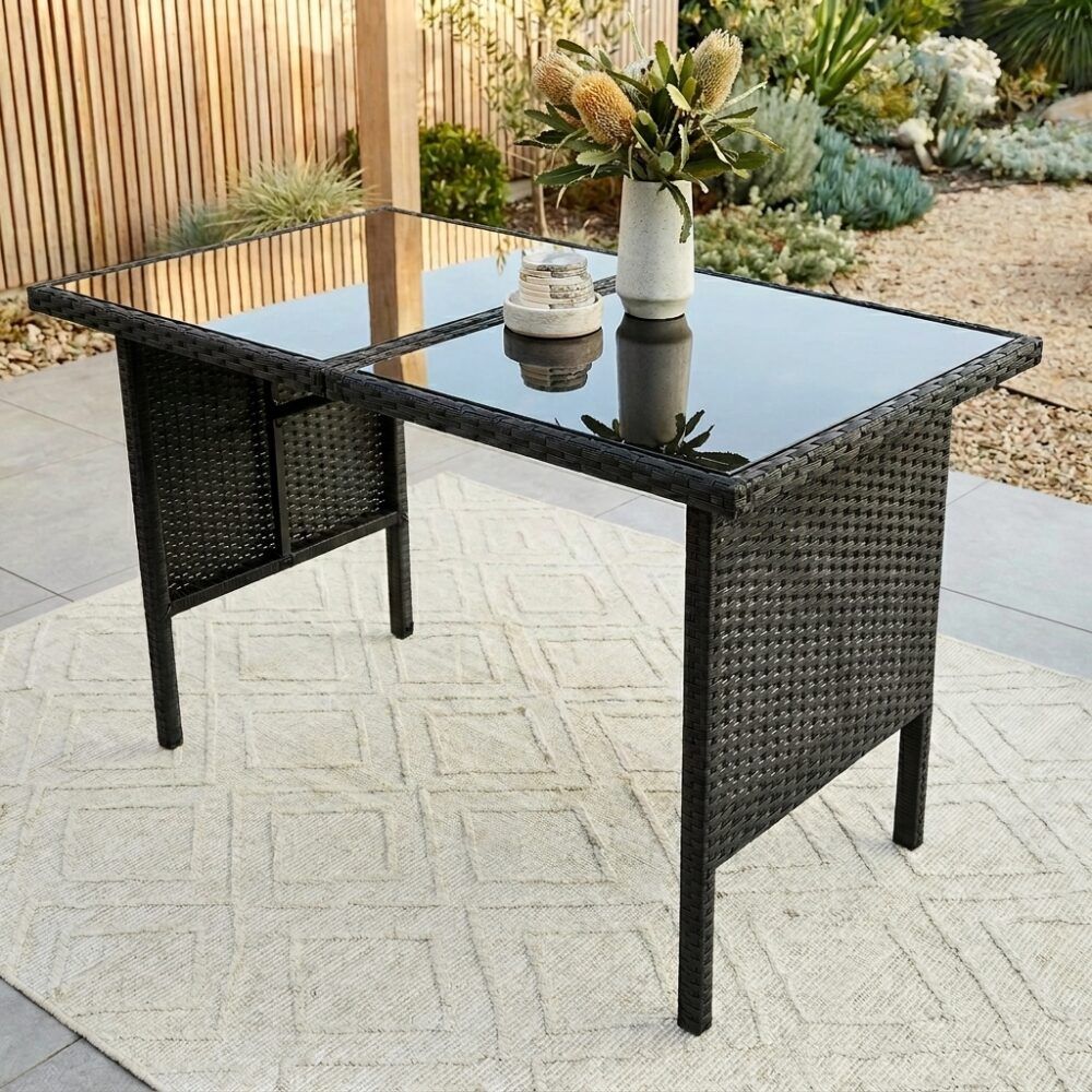 Black outdoor dining table with woven legs and matching corner stools