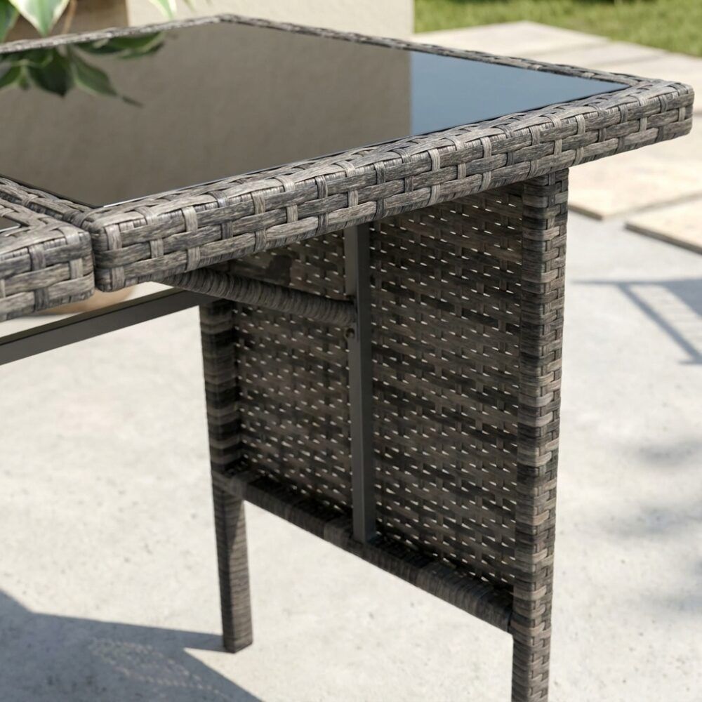 Close-up of dark grey woven table base with glass top and metal support legs