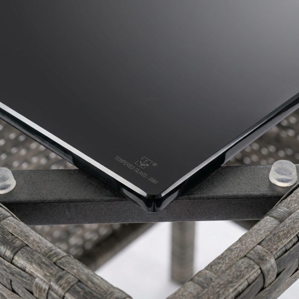 Close-up of dark tabletop edge with corner bracket on woven table frame