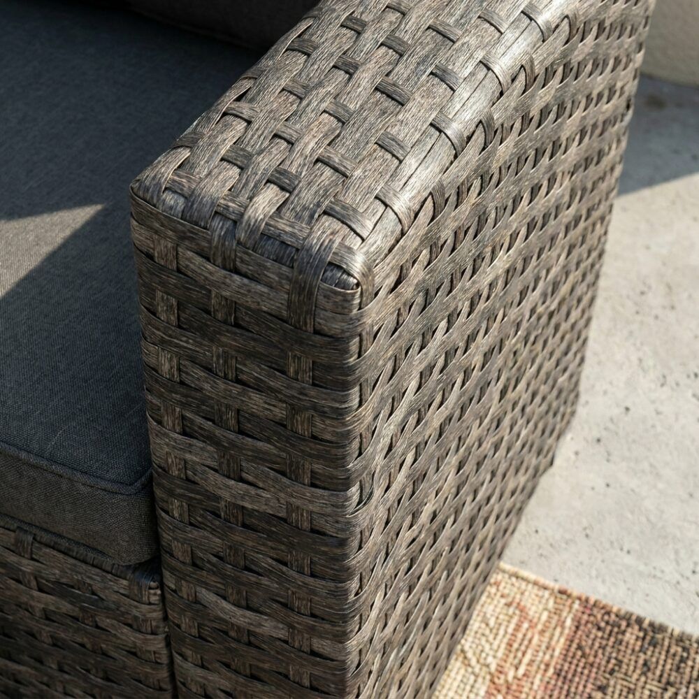 Close-up of dark grey woven ottoman corner with stitched weave pattern