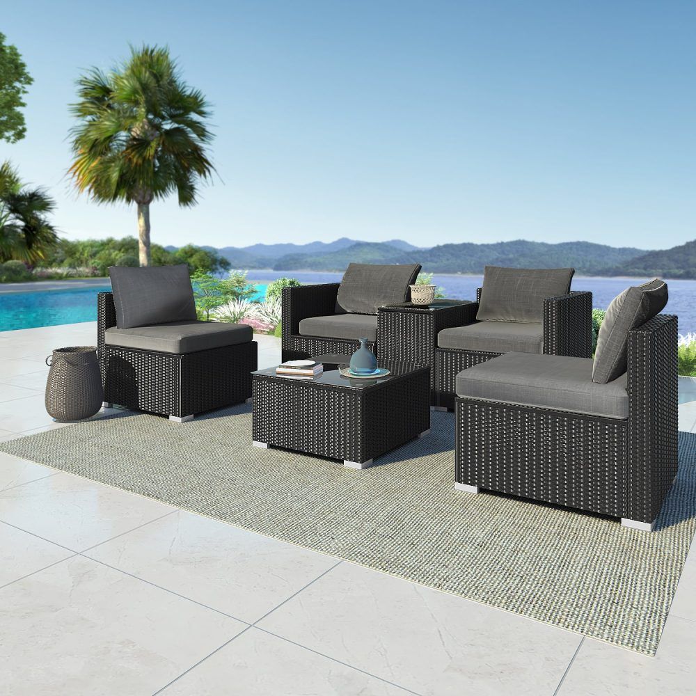Outdoor wicker lounge set with gray cushions and dark frames, with a central glass-top table