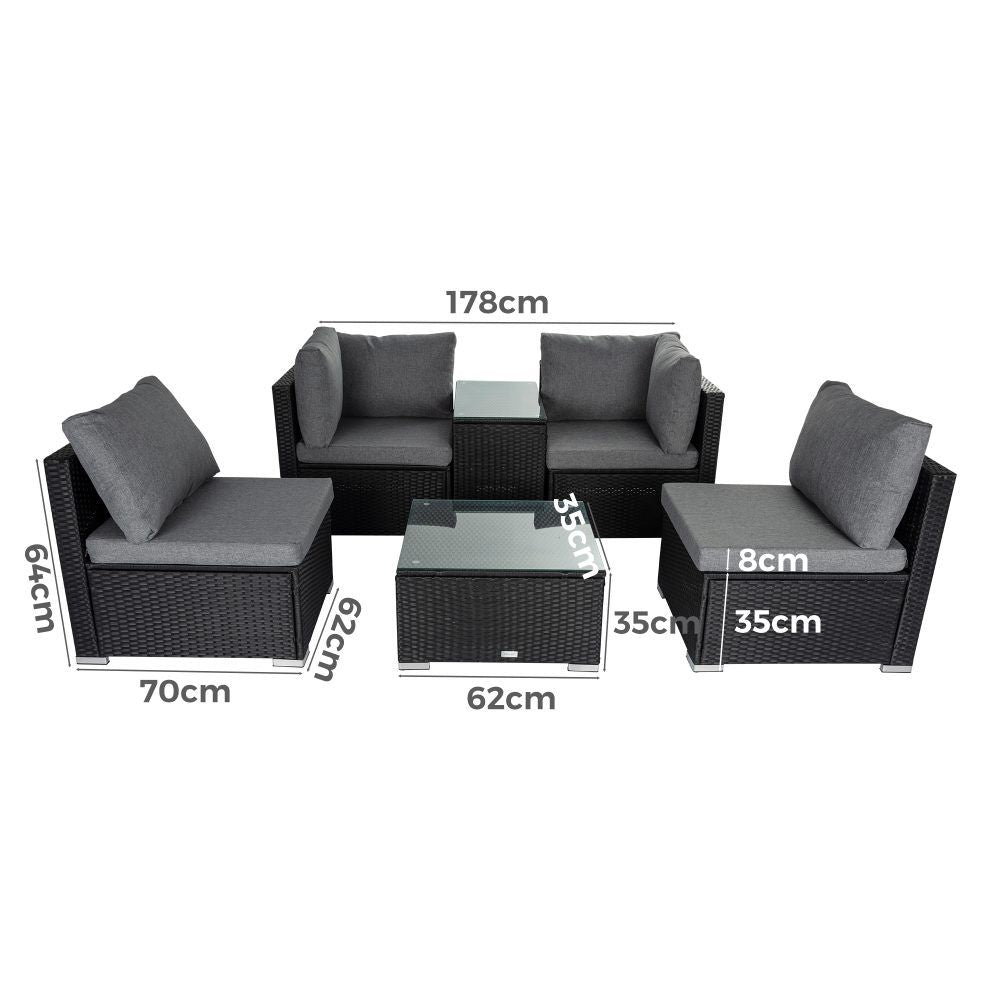 Modular outdoor wicker lounge set with dark cushions and glass-top coffee table
