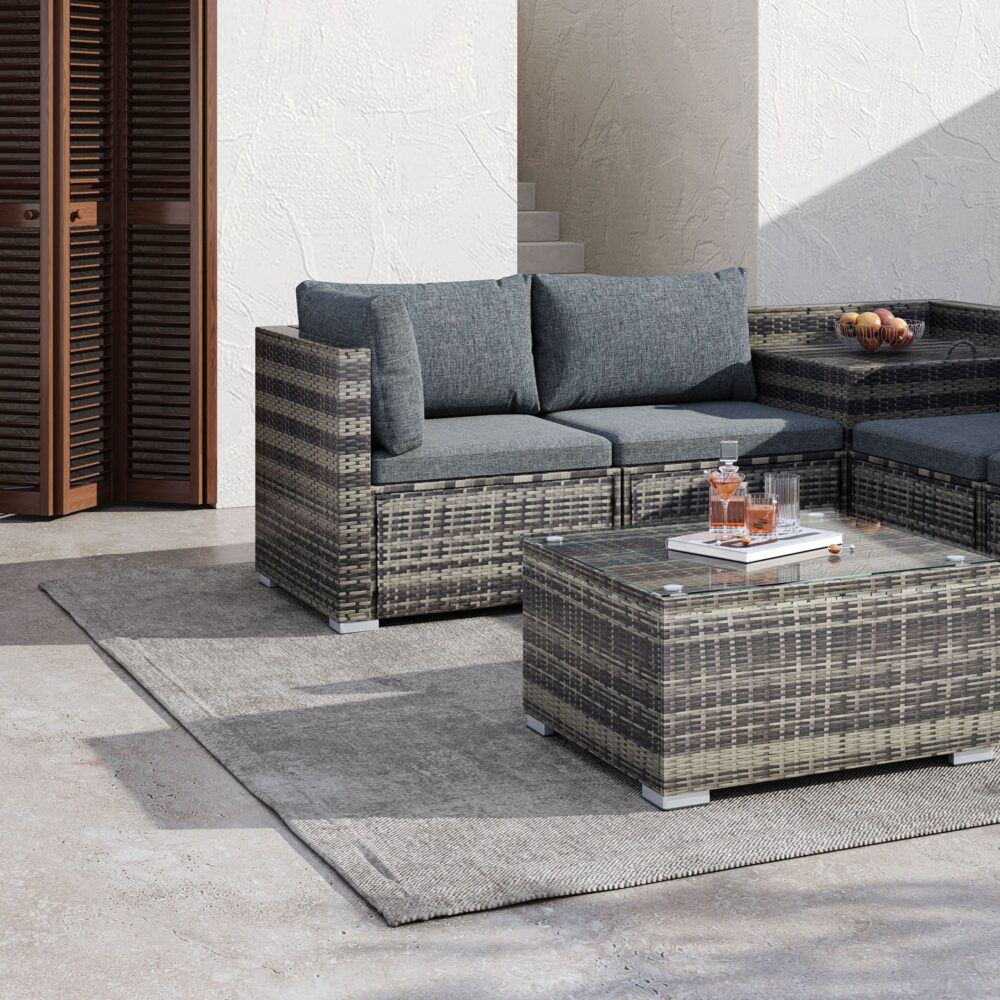 Outdoor corner sofa with gray cushions and woven-style coffee tables on patio