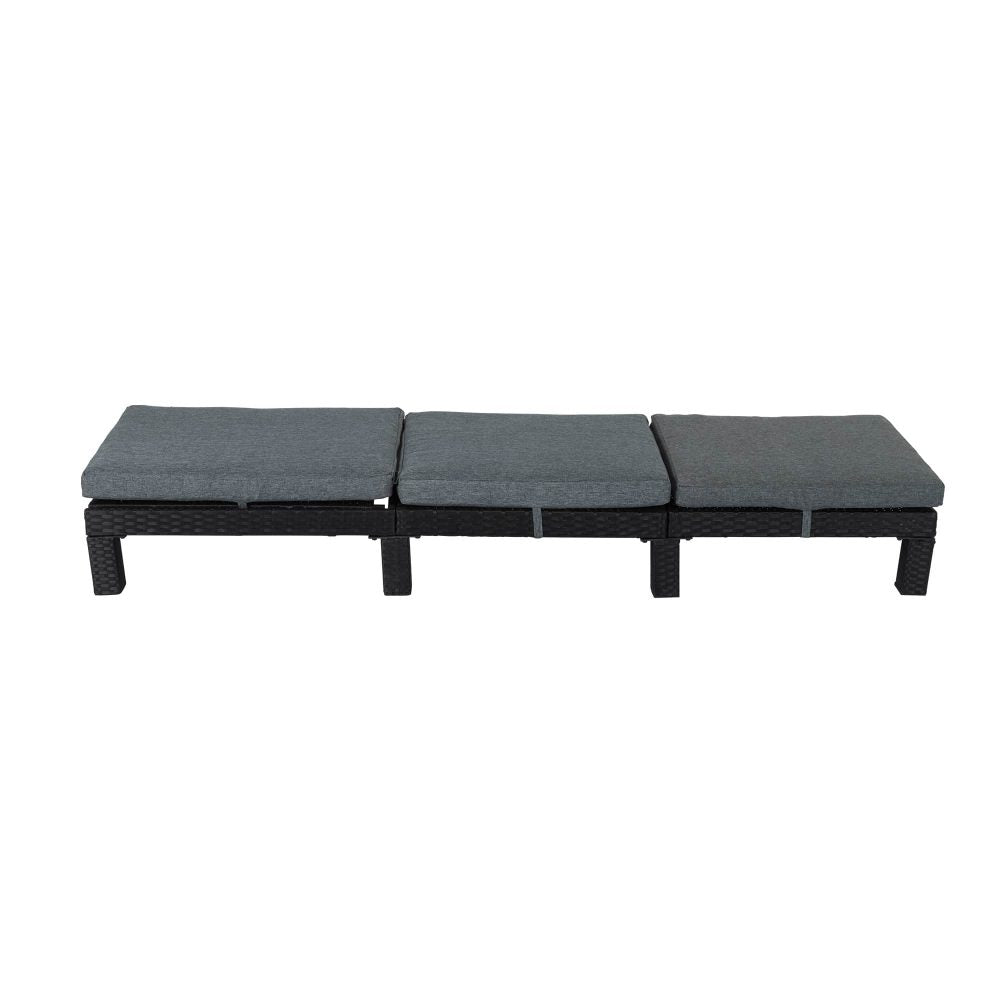 Rattan sunbed with dark frame and three-part gray seat cushions, flat lounge position