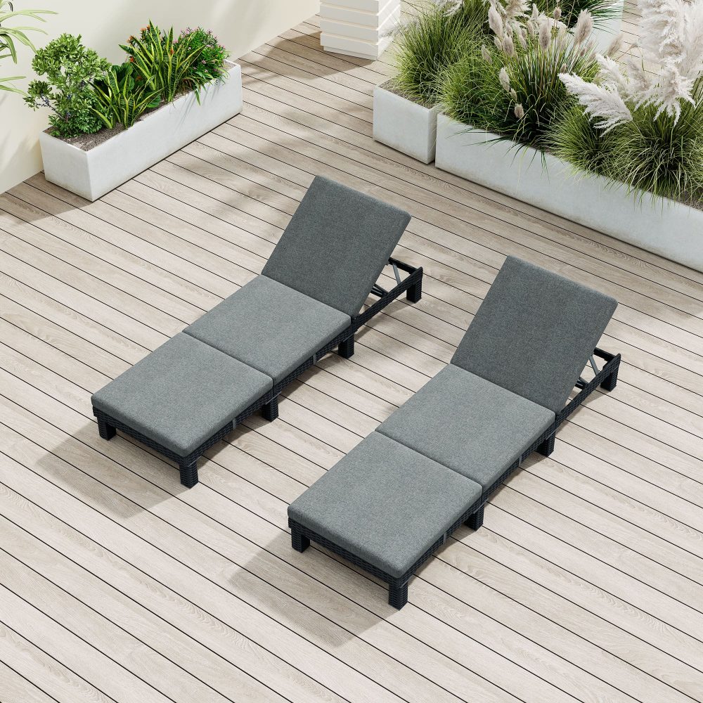 Two adjustable rattan sunbeds with dark frames and gray cushions on patio deck
