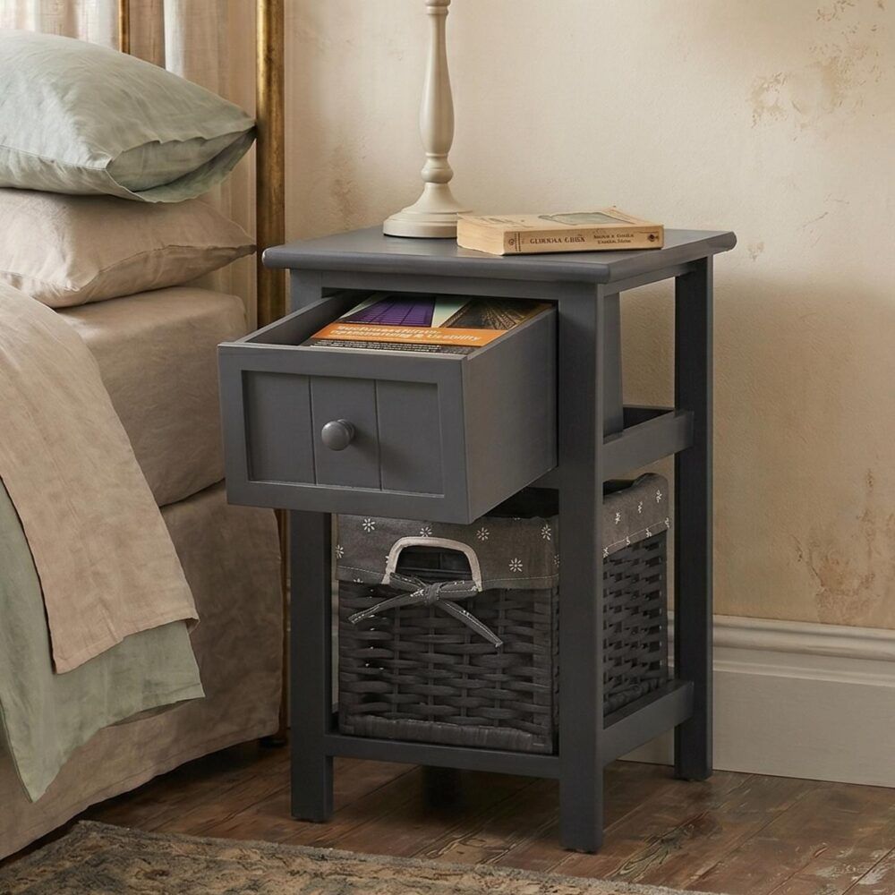 Grey bedside table with drawer and open wicker basket holding folded items.