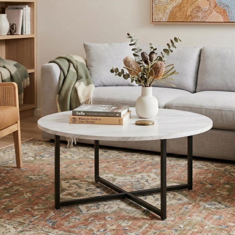 Round coffee table with white marble-effect top and black metal frame legs