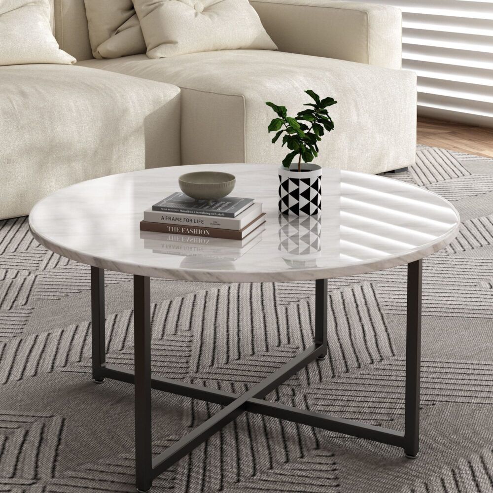 Round coffee table with white marble-effect top and black cross-brace legs