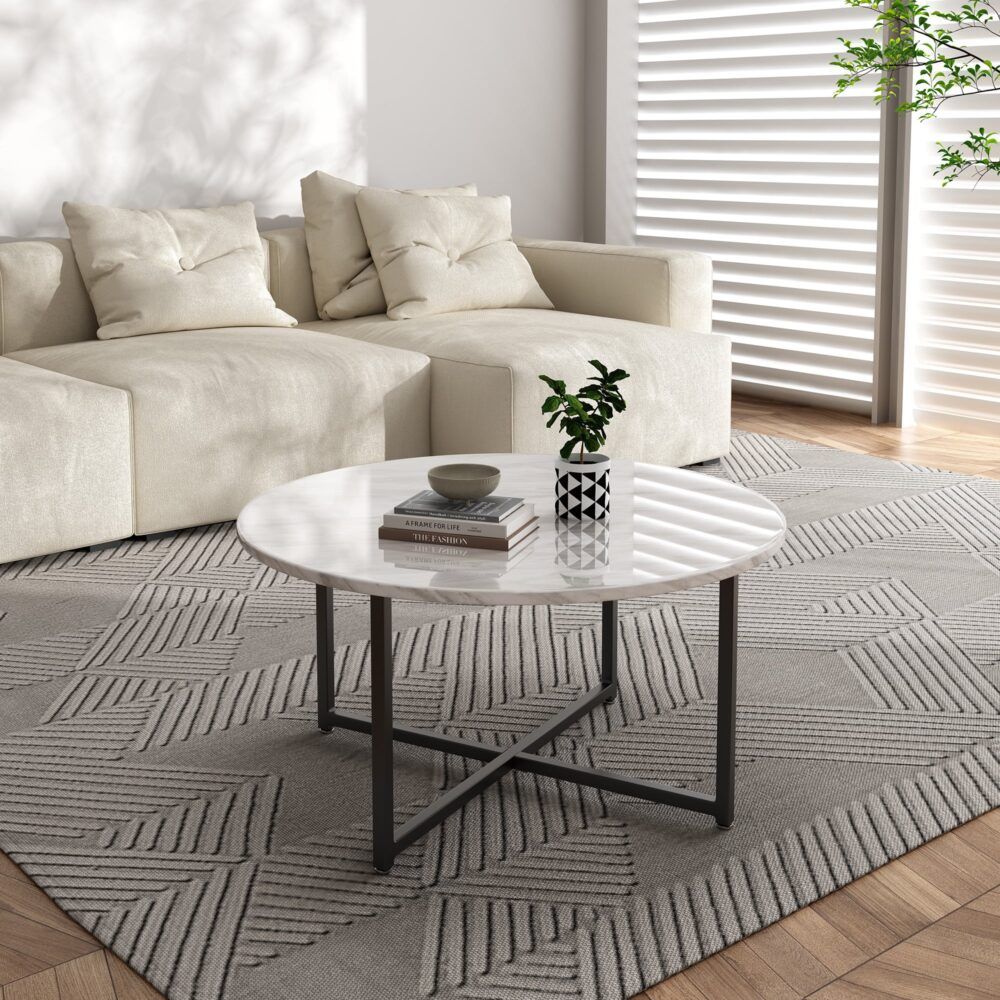 Round coffee table with white marble-effect top and black X-shaped legs