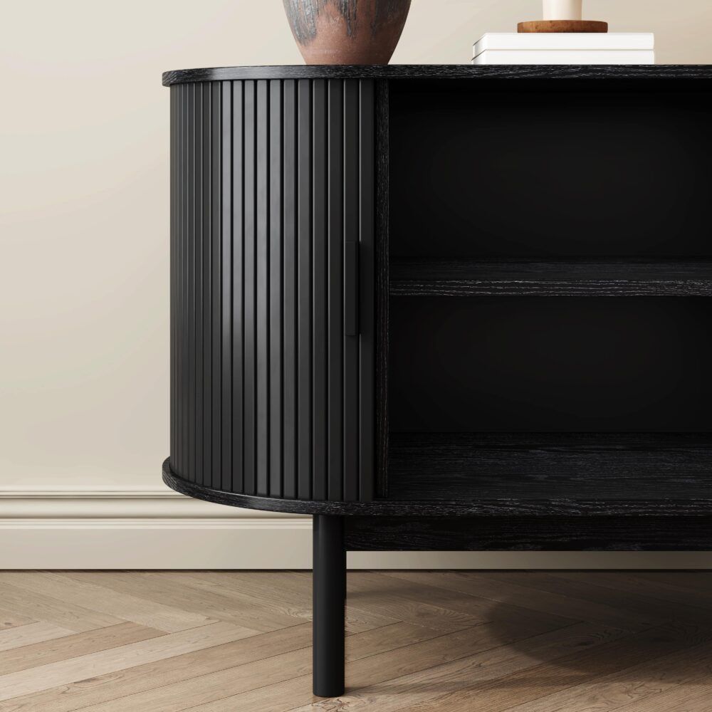 Black ribbed cabinet corner with open door and dark interior shelf, on tapered legs