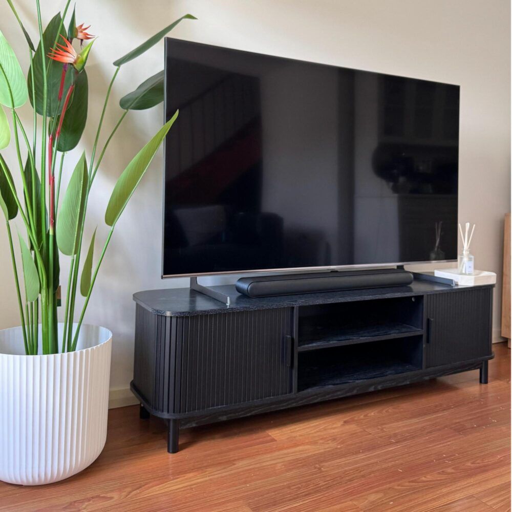 Ribbed black TV stand with open shelves and side cabinet doors