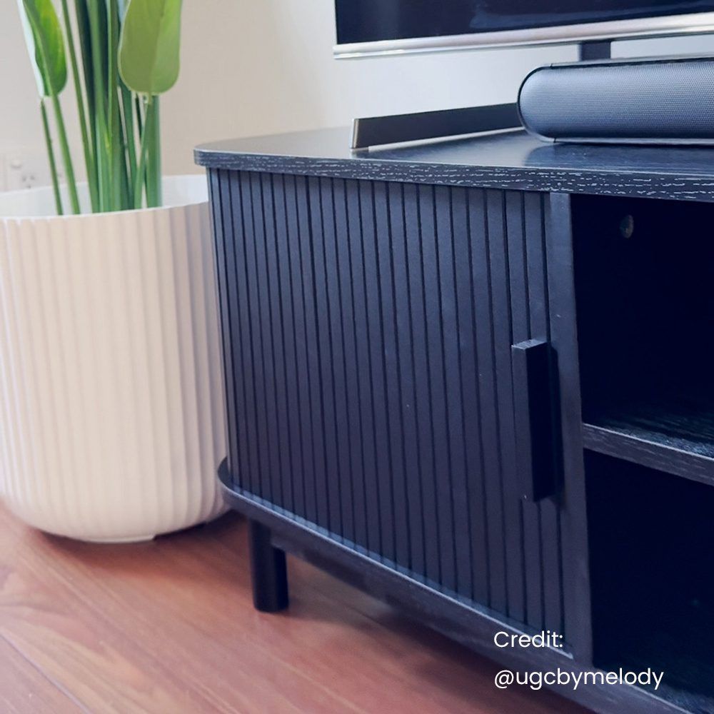 Ribbed black cabinet side with vertical grooves and a recessed handle