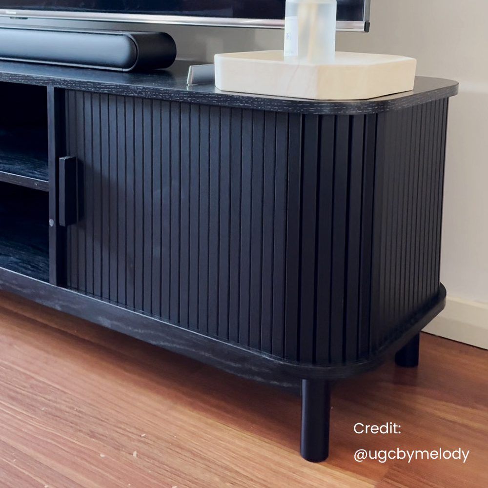 Ribbed black entertainment unit base with vertical doors and dark legs