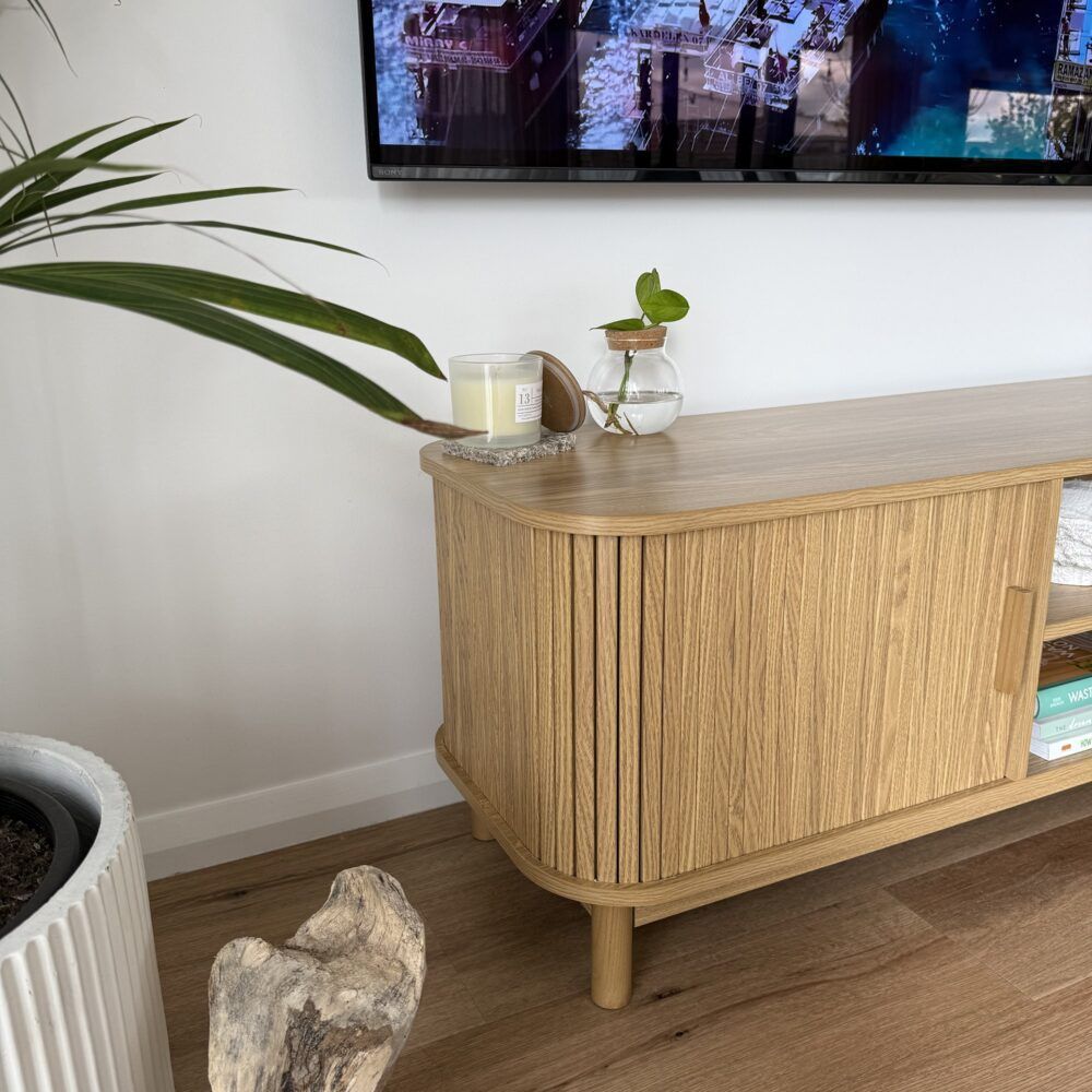 Light wood ribbed entertainment cabinet with rounded corners and open shelf