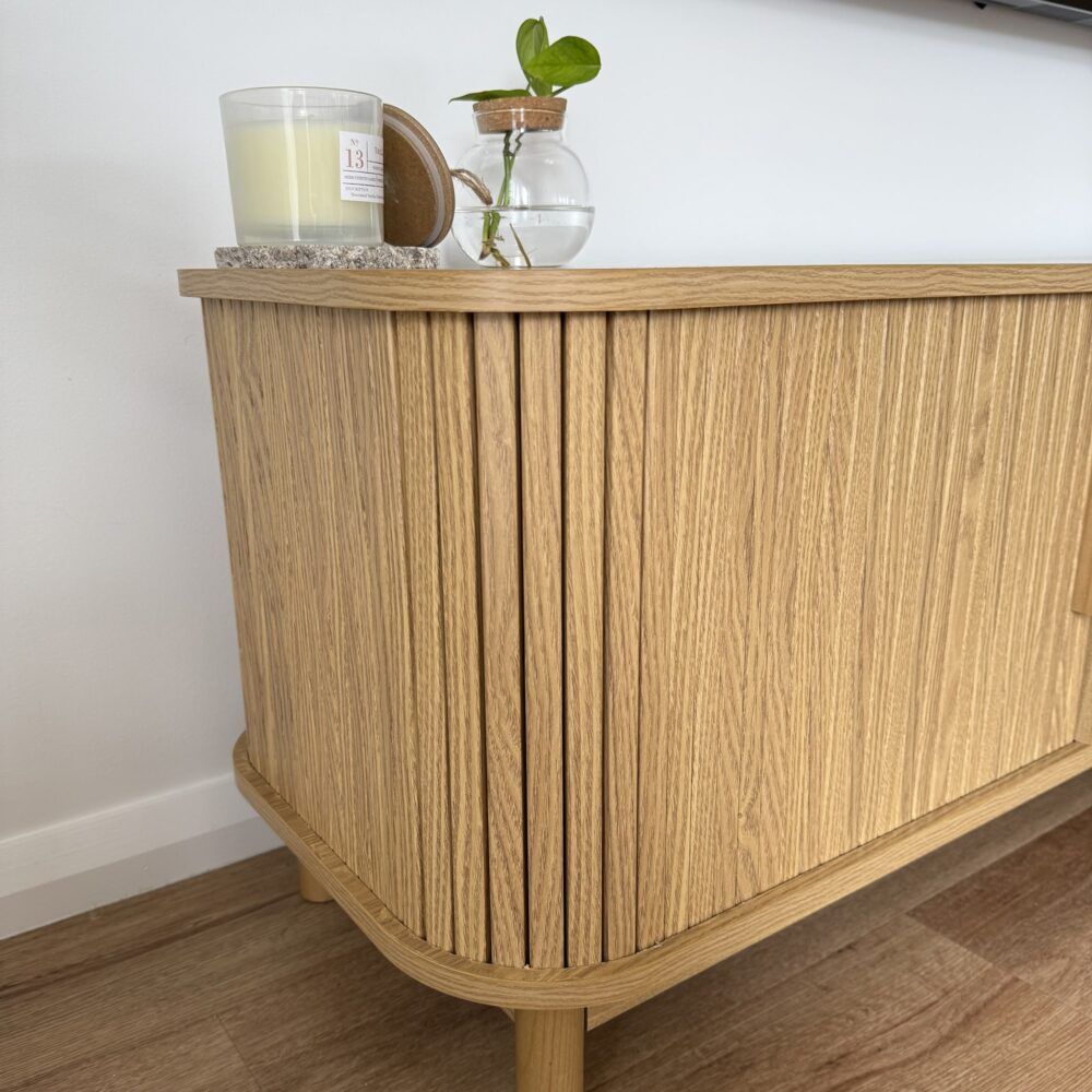 Light wood entertainment cabinet with two doors and ribbed vertical front panels