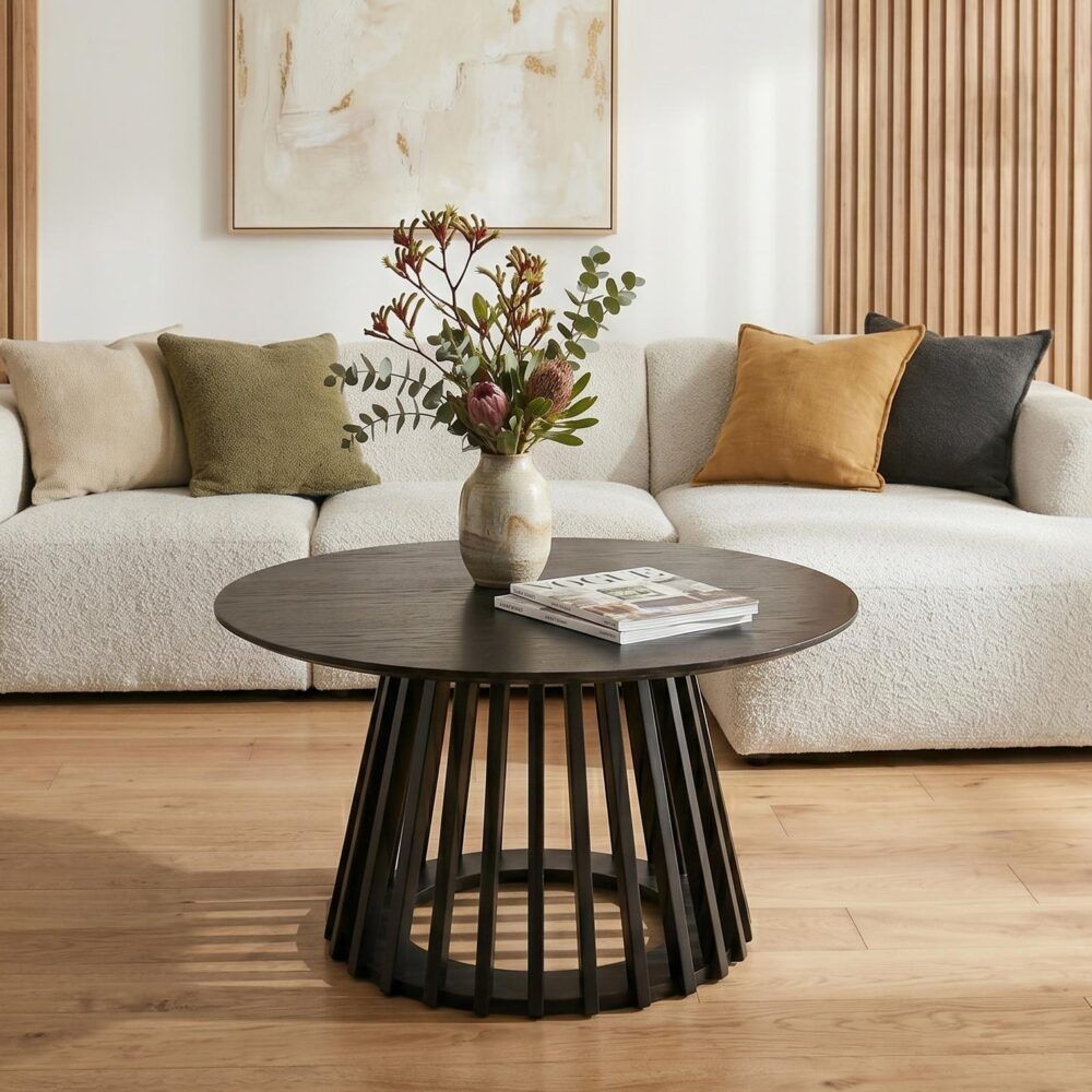 Round dark wood coffee table with slatted pedestal base and subtle woodgrain top.