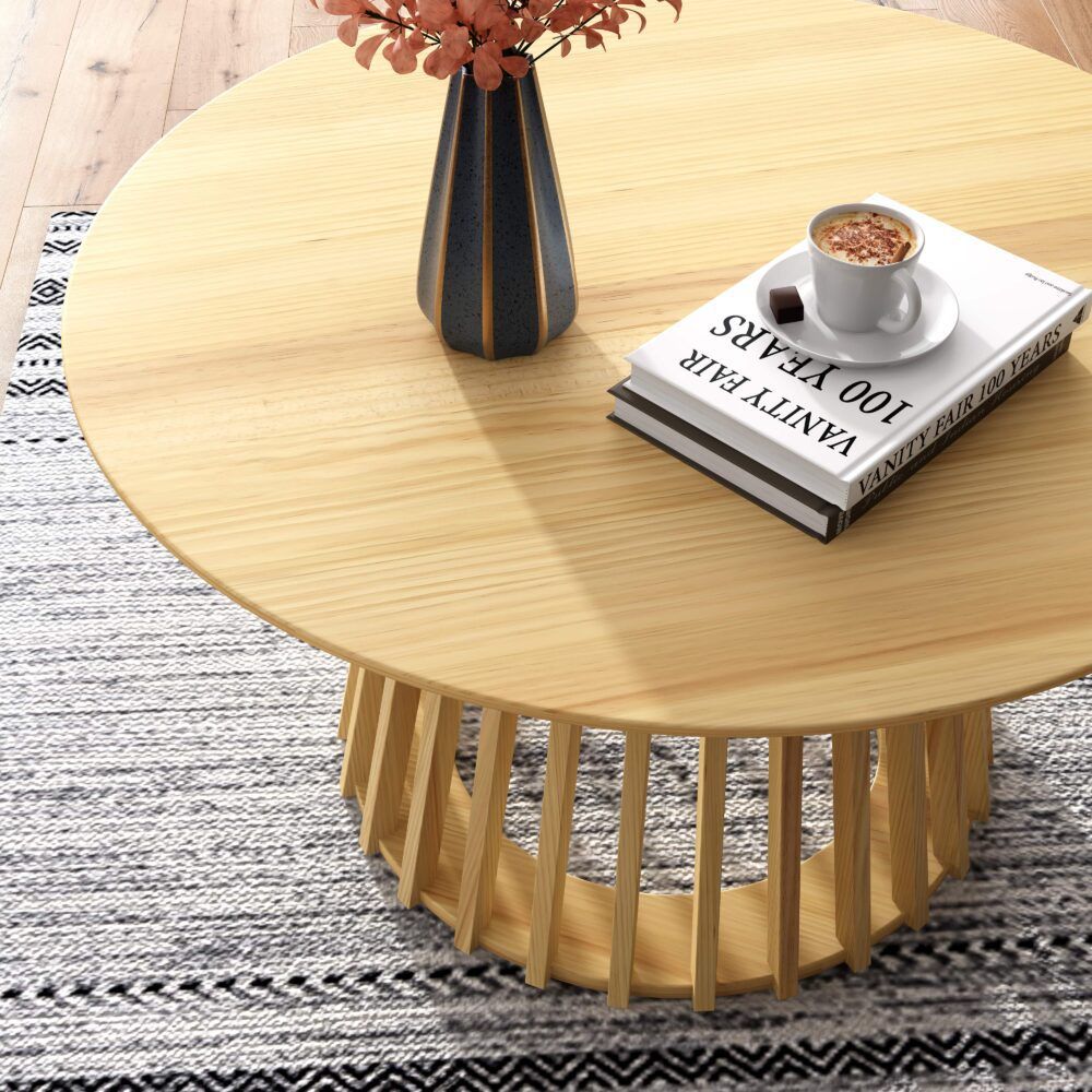 Round light wood coffee table with slatted base, close side angle