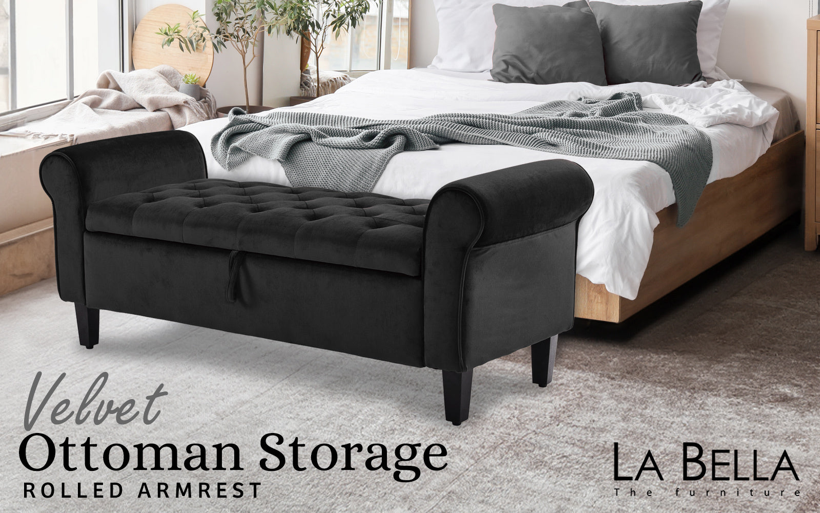 Black velvet storage ottoman with rolled arms and tufted seat, square base legs.