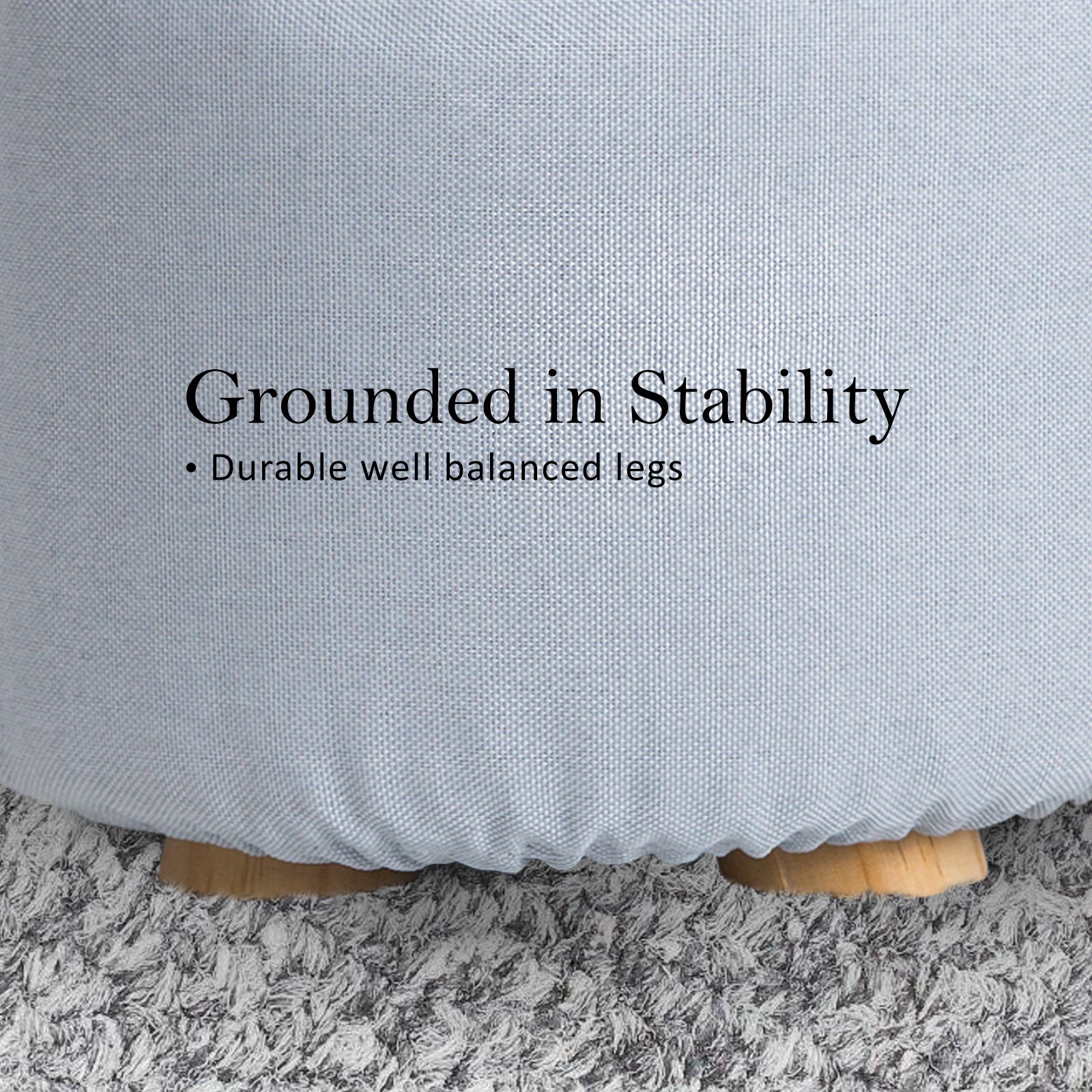 Light blue round fabric ottoman with sturdy legs and padded rim