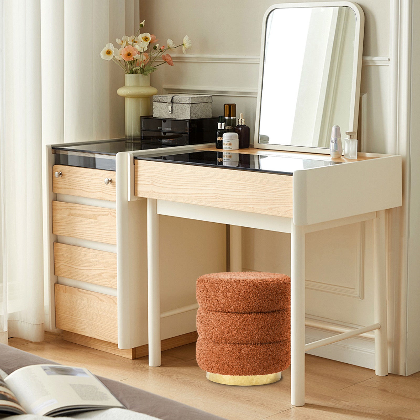Stacked round ottoman stool in orange teddy fleece under a white cabinet table