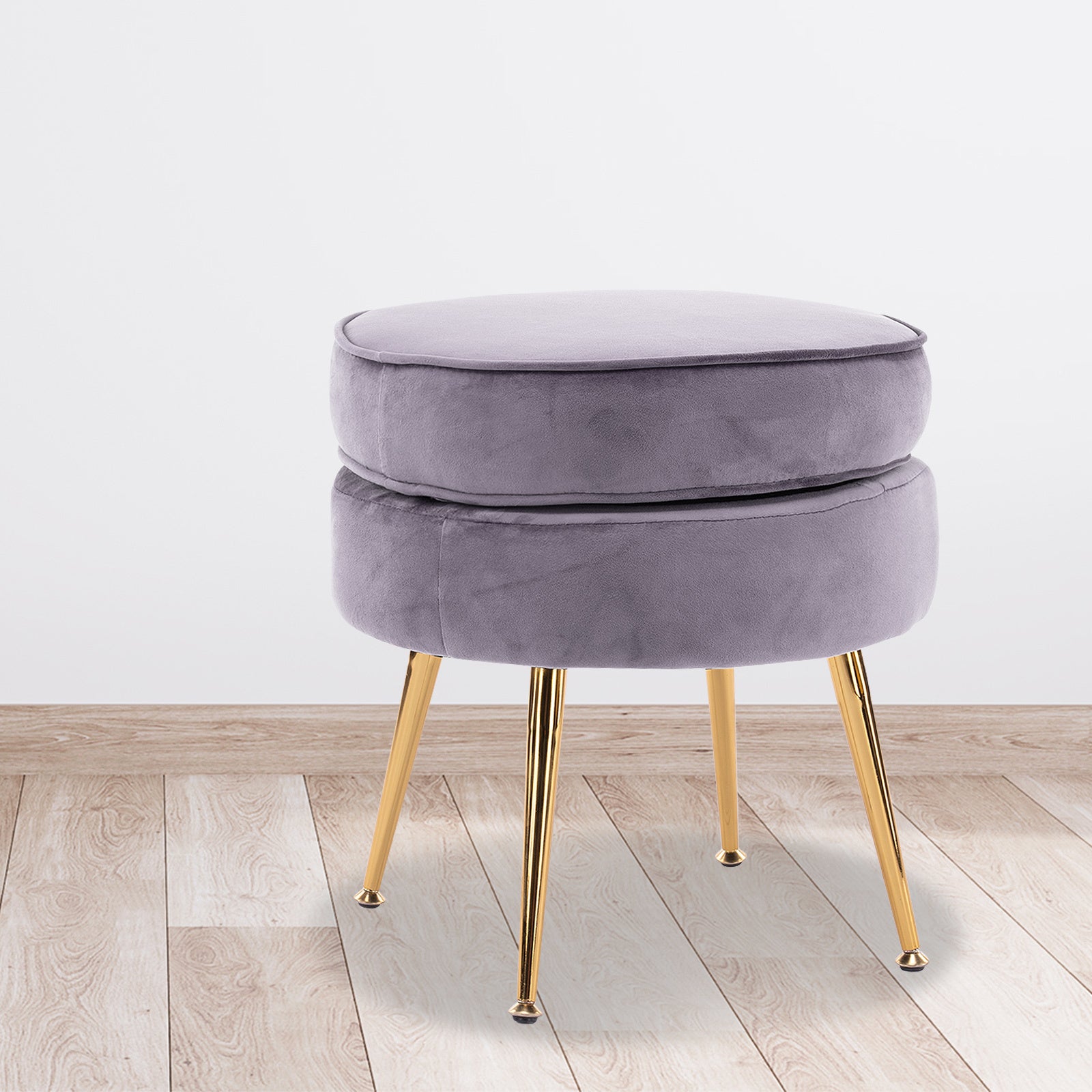 Round light gray velvet ottoman with gold metal legs and cushioned top