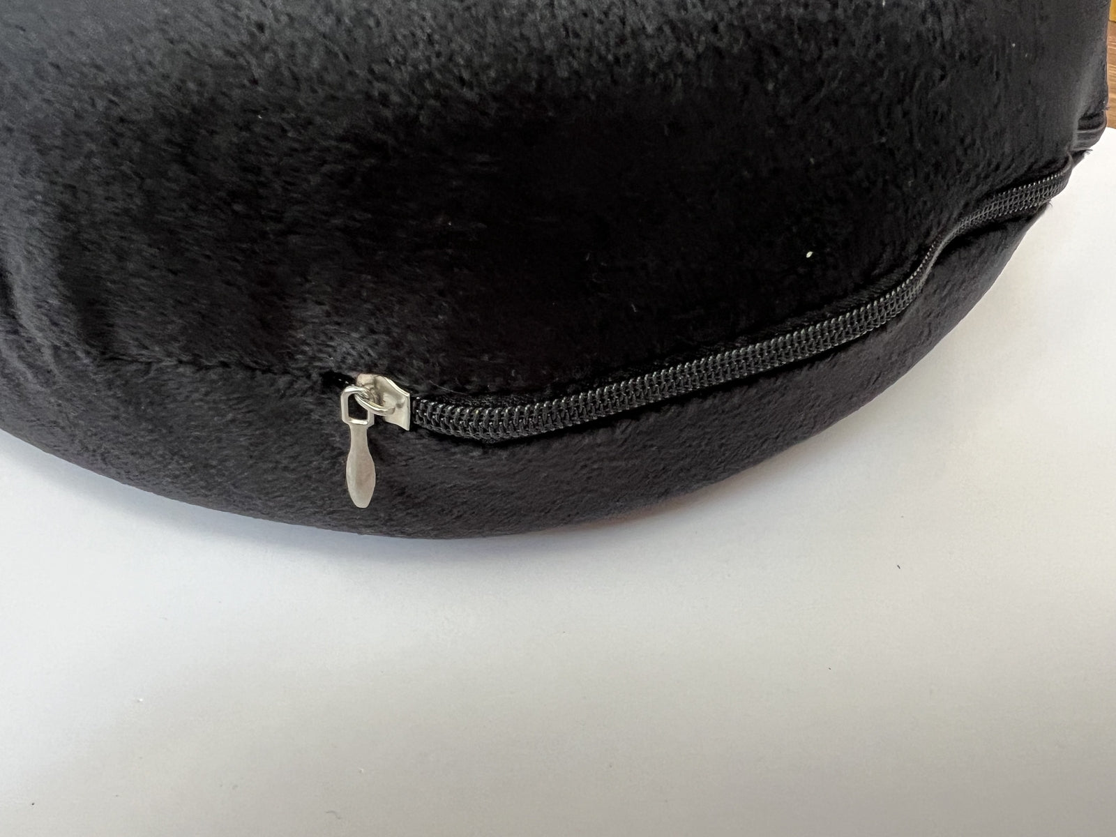 Dark U-shaped neck pillow edge with black zipper and metal pull tab