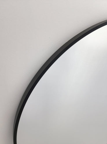 Black arched mirror frame close-up with smooth curved border