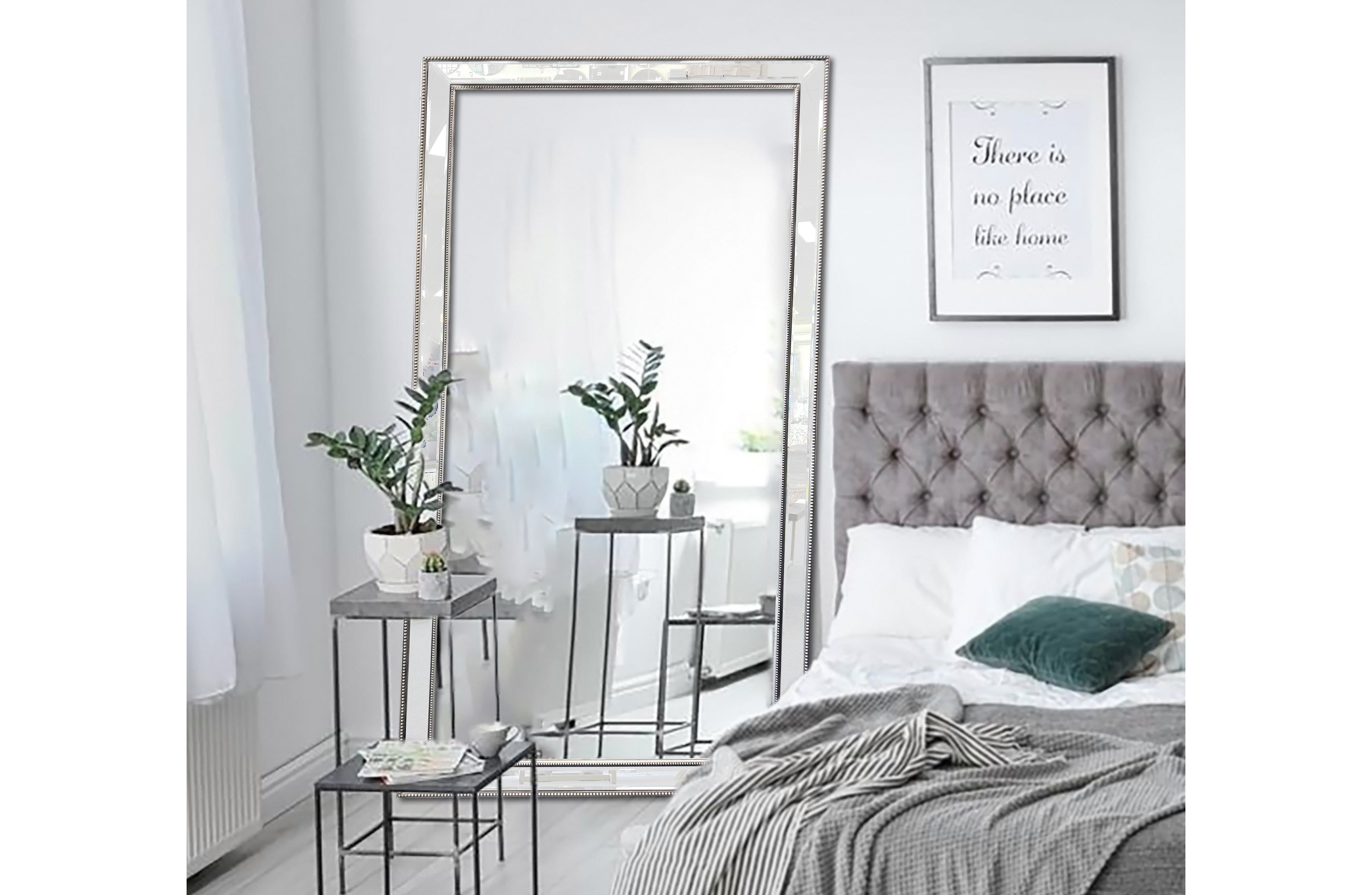 Large rectangular silver mirror with beaded frame above bed in bedroom
