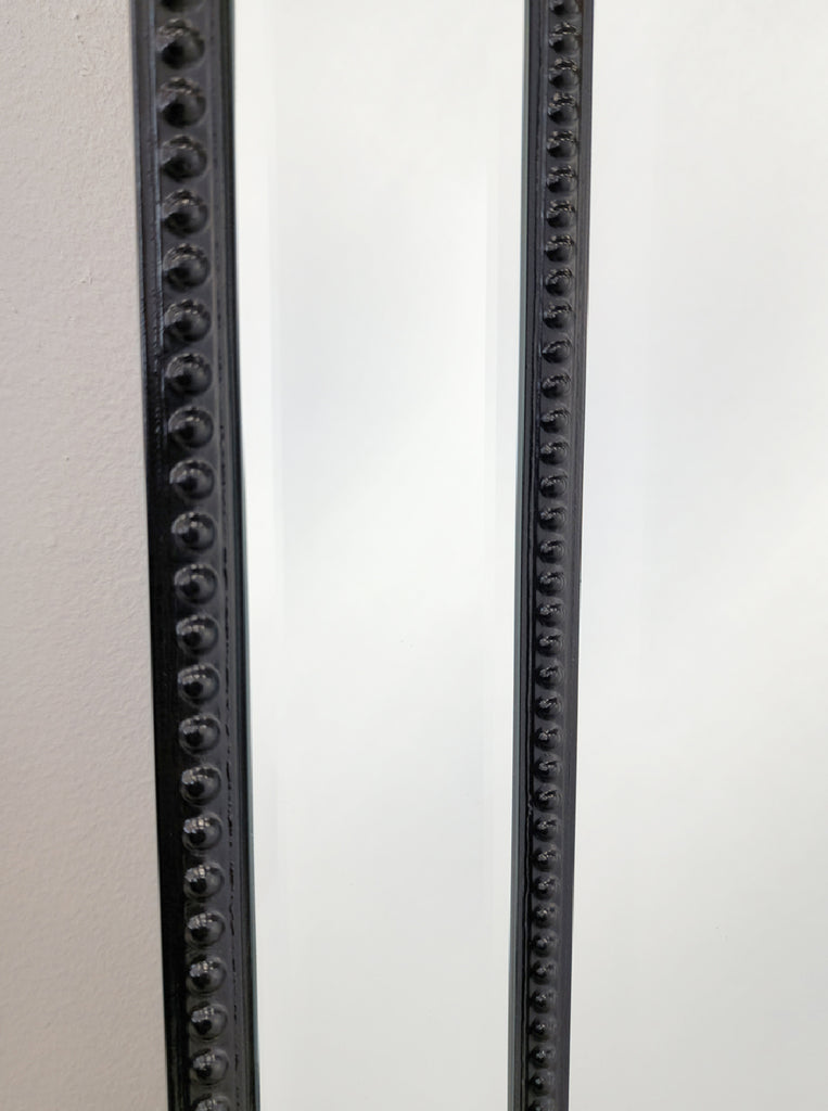 Black beaded mirror frame detail with textured round studs